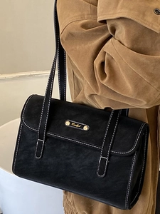 Retro black suede shoulder bag with contrast white stitching and gold buckle detail