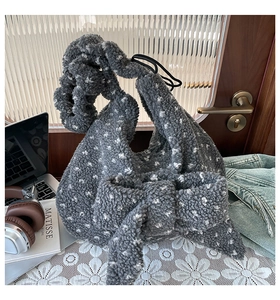 Close-up of plush polka dot handbag with large bow decoration and soft fleecy texture