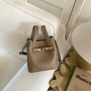 Close-up of brown lychee grain leather bucket bag with silver metal swivel lock detail