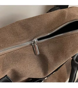 Detailed macro view of smooth silver metal zipper on premium canvas travel bag