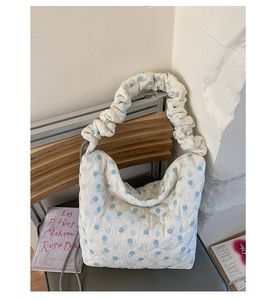 Detail of white quilted tote bag with blue dots and unique scrunchie cloud strap