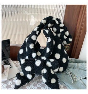 Detail shot of winter plush polka dot bag with large bow and soft drawstring texture