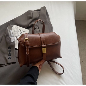 Detailansicht der dunkelbraunen Lederhandtasche mit hellen Nähten und goldenen Schnallen