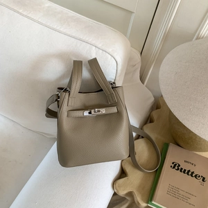 Detailed shot of khaki lychee grain leather bucket bag with silver metal swivel lock