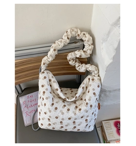 Detail of beige canvas tote bag with brown polka dots and scrunchie shoulder strap