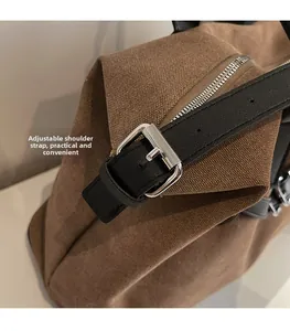 Macro detail of adjustable black leather strap with silver buckle on brown canvas tote bag