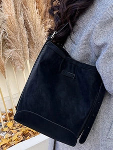 Minimalist black suede tote bag for women, stylish shoulder bucket bag shown on a model