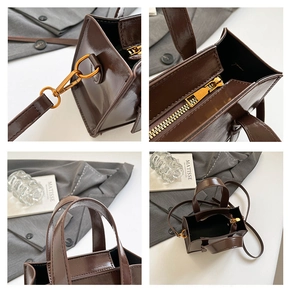 Detail view of glossy brown leather tote with vintage gold zippers and strap hooks