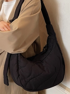 Minimalist black quilted shoulder bag with spacious curved design for daily commuting