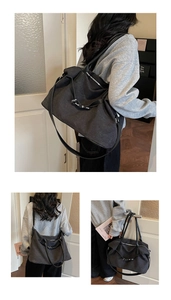 Detail showing the versatile black canvas tote bag with leather straps and silver buckle