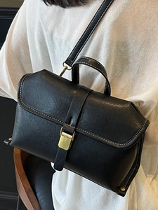 Retro Handtasche aus schwarzem Leder mit weißen Kontrastnähten und goldener Schnalle