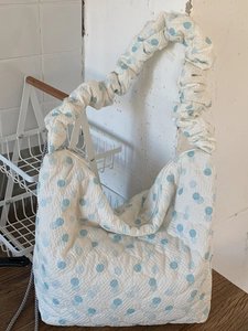 Minimalist white hobo bag with blue polka dots and quilted texture for winter 2025