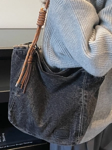 Chic dark wash denim tote bag with brown woven rope straps and spacious minimalist design