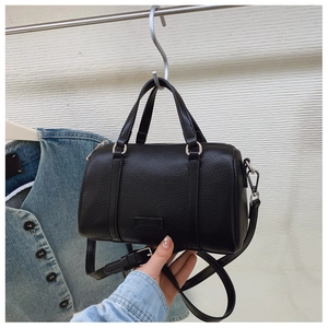 Detail of black lychee grain leather boston bag with silver hardware and CEHEKA logo