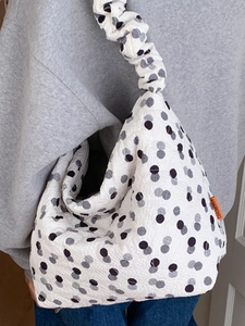 White quilted tote bag with black polka dots and a ruffled scrunchie style shoulder strap
