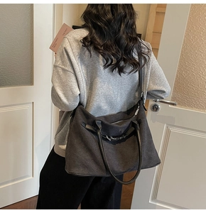 Detail of a large canvas tote bag showing silver buckle and durable shoulder strap