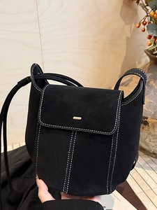 Classic black suede bucket bag with contrast white stitching and gold buckle detail