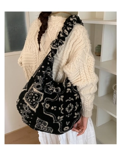 Dettaglio della borsa tote in peluche con motivo paisley bianco e nero e consistenza soffice