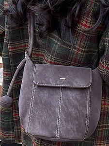Retro dark brown bucket bag with contrast stitching and decorative ball charm