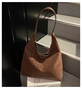 Détail de la texture léopard marron sur un sac cabas vintage en daim sur des livres