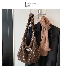 Sac cabas en peluche marron à pois avec bandoulière plissée sur un crochet mural
