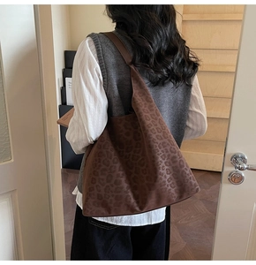 Détail d'un sac cabas léopard vintage avec texture douce porté sur l'épaule du modèle