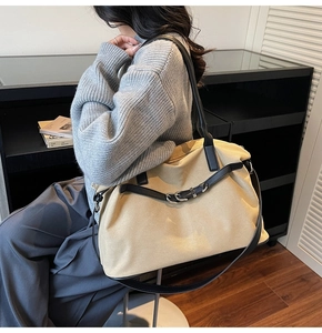 Detail of vintage tote bag with beige fabric, black leather trim and metal buckle detail