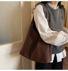 Gros plan du sac hobo à imprimé léopard avec bandoulière large en texture daim mate