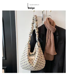 Détail du sac bandoulière en peluche beige à pois bleus et poignée au style plissé