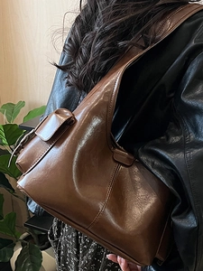 Retro brown PU leather shoulder bag with side pocket shown on a stylish model