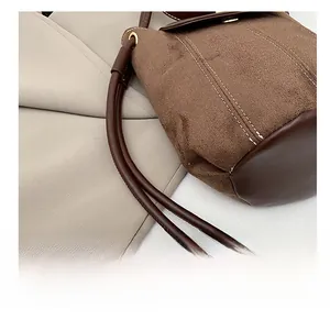 Detail of vintage bucket bag featuring brown suede stitching and white double stitching
