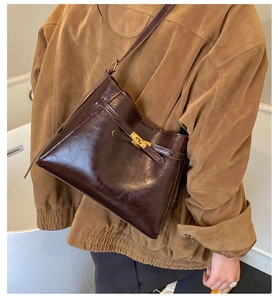 Détail du sac à main en cuir marron foncé avec fermoir rotatif métallique et sangle