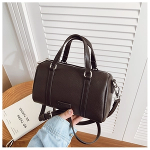 Detailed macro view of dark brown litchi textured leather handbag with silver hardware
