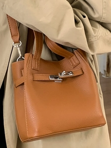 Classic caramel pebble leather bucket bag with top handles and adjustable shoulder strap