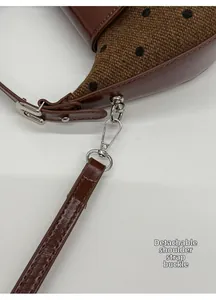 Gros plan du crochet métallique amovible sur un sac à bandoulière à motif à pois