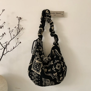 Dettaglio della borsa tote in peluche con motivo paisley e tracolla arricciata