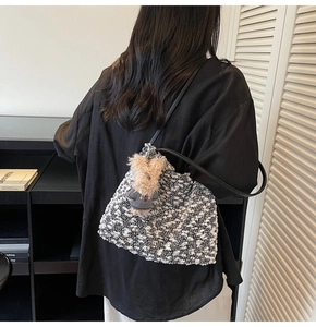 Détail du sac cabas en tweed avec bandoulières en cuir noir et breloque ours en peluche
