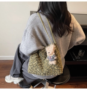 Détail du sac fourre-tout en polaire verte avec un pendentif ours en peluche mignon