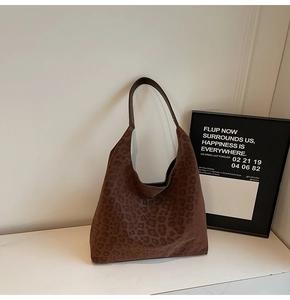 Vue détaillée du sac hobo léopard en daim avec une bandoulière au style minimaliste