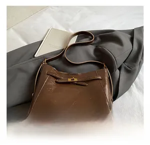 Détail d'un sac sous les aisselles en cuir marron rétro avec boucle dorée sur un blazer