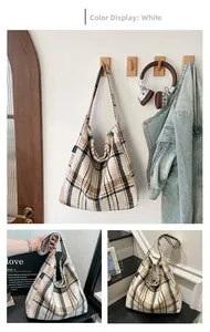 Detail showing vintage plaid tote bag texture and brand label on woven tweed fabric