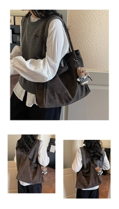 Detail view of large dark brown suede tote bag with a cute striped bear pendant accessory