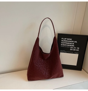 Détail du sac cabas hobo bordeaux avec motif léopard et texture en daim gaufré