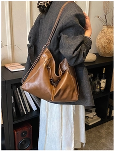 Brown leather tote bag featuring contrast stitching and large capacity for daily commuting