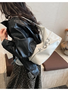 Detailed side view of white leather shoulder bag showing glossy texture and metal buckles