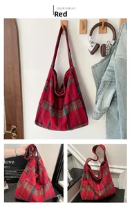 Detail view of large red plaid tote bag made of thick wool fabric with shoulder straps