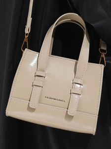 Minimalist beige patent leather crossbody bag with top handles and fashion text logo
