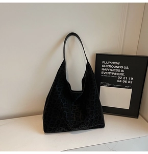 Détail de la texture léopard sombre et de la bandoulière en cuir noir sur ce sac hobo chic
