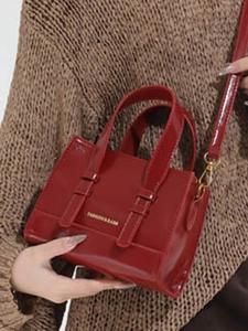 Deep red patent leather crossbody square bag with gold hardware and top handles
