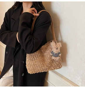 Sac fourre-tout marron en peluche avec breloque ours porté sur un blazer noir d'hiver